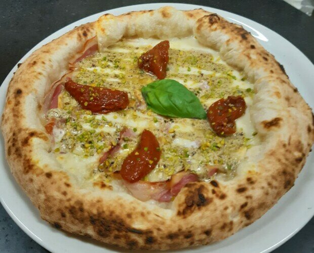 grottone 2.0. pizza con mozzarella di bufala campana, pistacchio di bronte, pomodori e pancetta